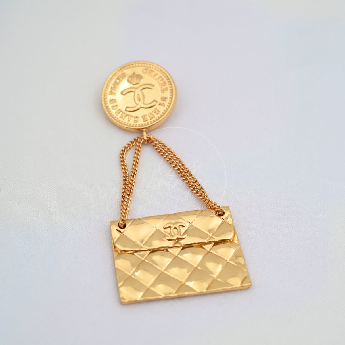 Chanel Vintage CC Medallion Flap Bag Brooch in 24K gold-plated, featuring interlocking CC emblem and attached chain, front view