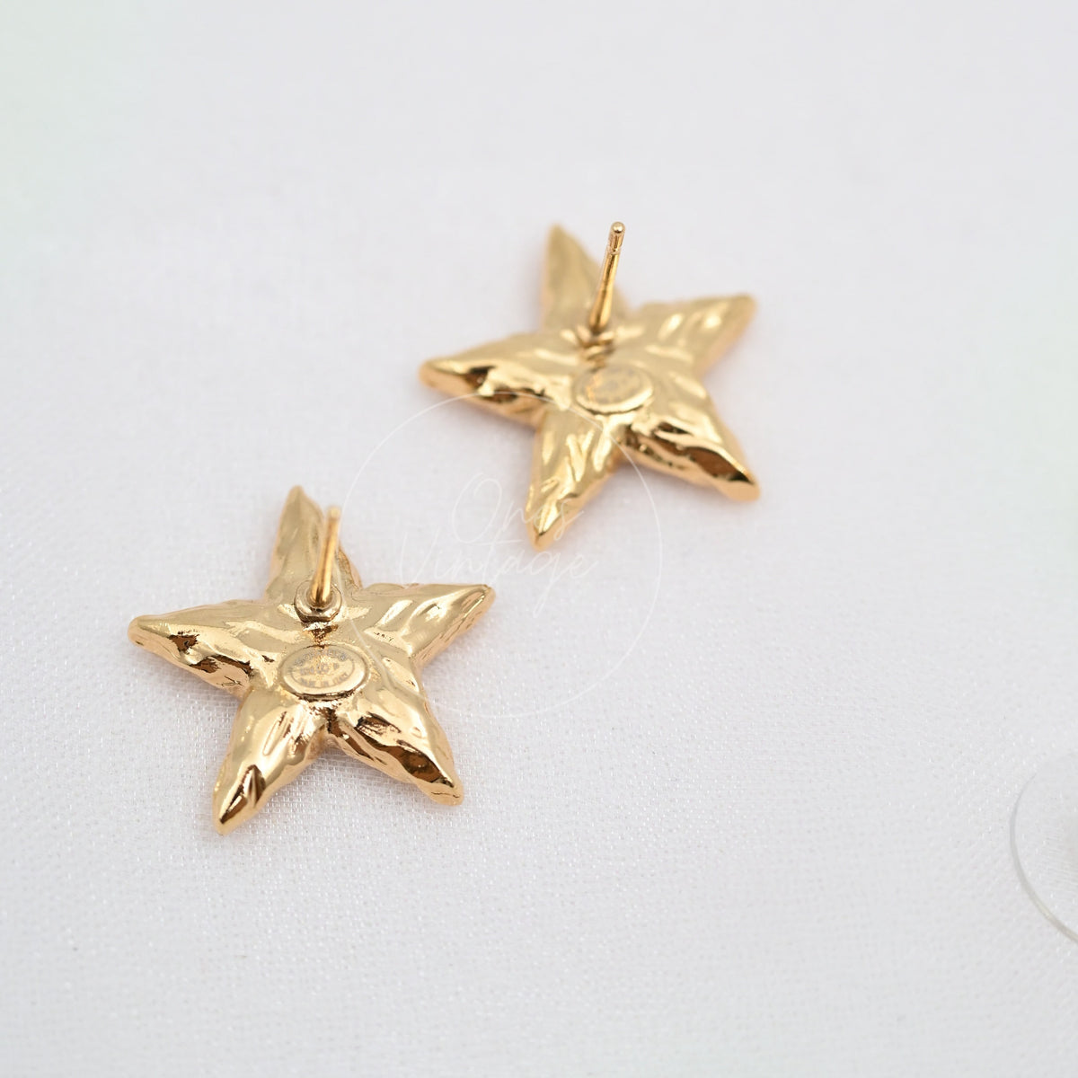 Chanel CC Mark on Gold Lava Star earrings in gold-plated alloy metal, featuring star-shaped earrings and central circular emblem, front view
