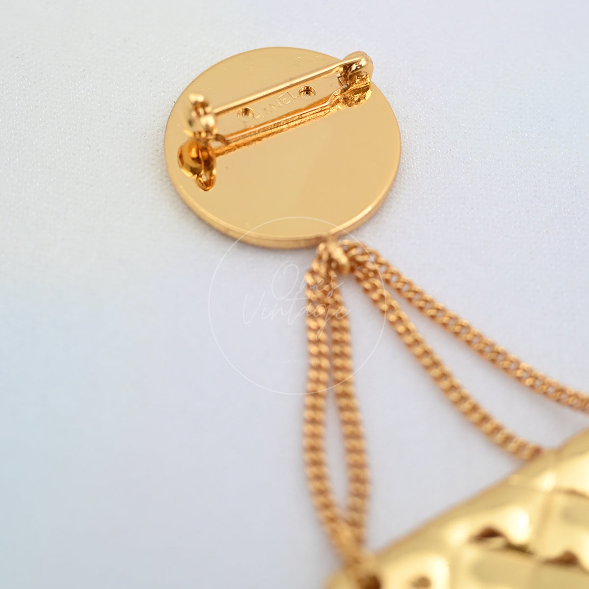 Chanel Vintage CC Medallion Flap Bag Brooch in 24K gold-plated, featuring bar pin closure and attached chain, back view
