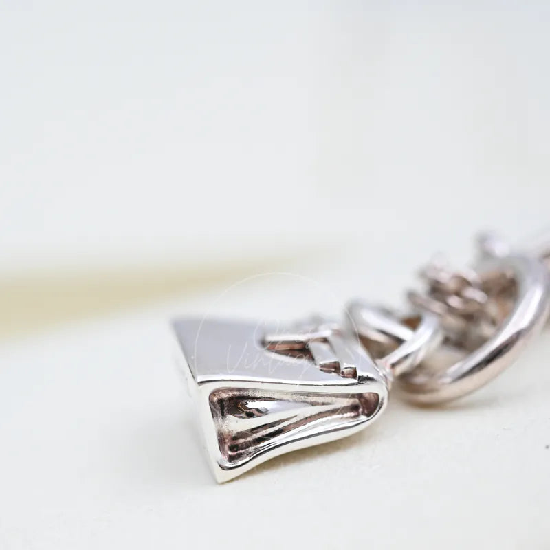 Hermès Amulettes Kelly Pendant Necklace, geometric triangular pendant and polished openwork surface detail