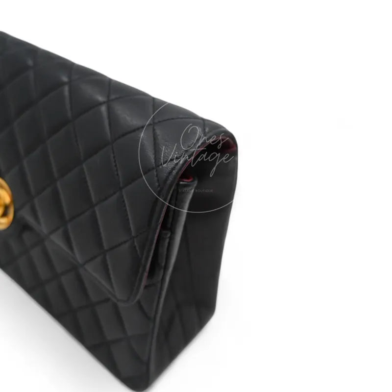Angled side view of Chanel vintage black lambskin bag showing flap edge and stitching