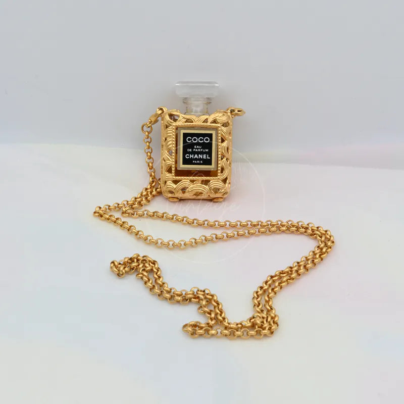 Chanel Perfume Bottle 18K Plated Necklace in 18K gold-plated and plastic, featuring perfume-bottle pendant and decorative textured border, front view