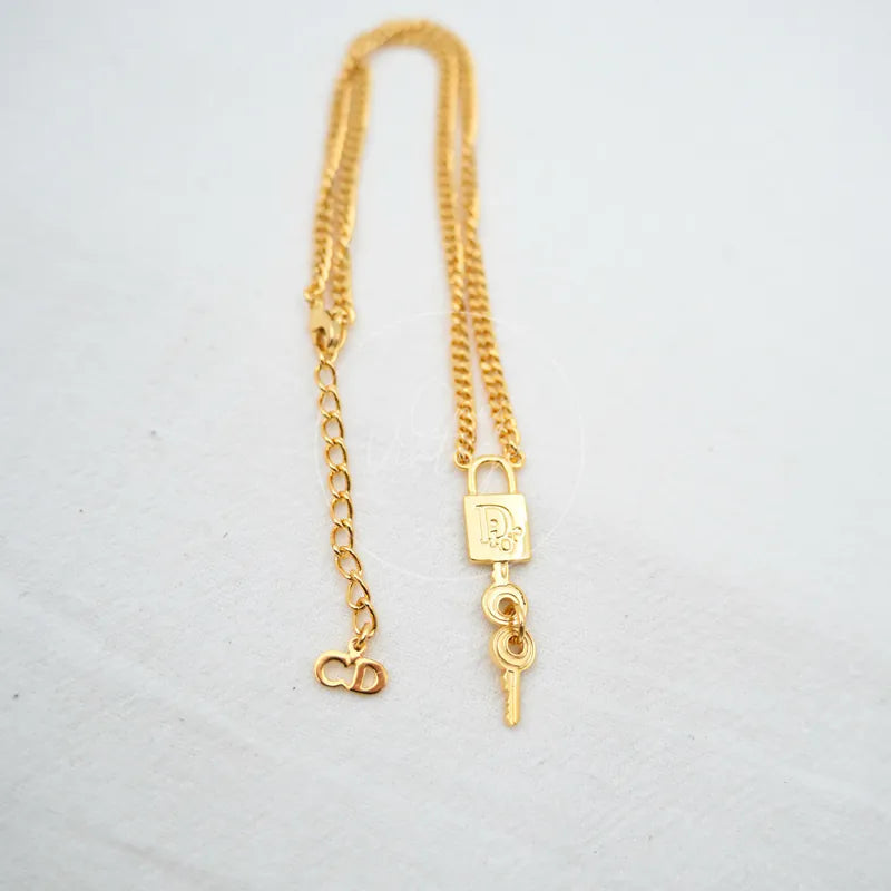 Dior Padlock Key Motif Necklace in alloy metal, featuring padlock pendant and dangling key charm, front view