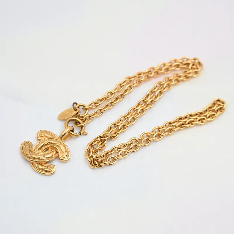 Chanel Matelasse Coco Mark Pendant Necklace in gold-plated metal, featuring interlocking CC pendant and lobster clasp, front view