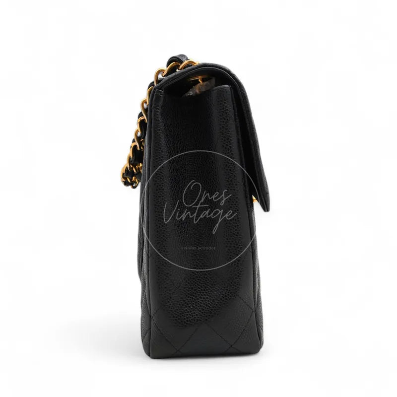 Chanel Jumbo Classic Flap Bag in black caviar with gold-tone hardware, featuring curved flap edge with chain shoulder strap, left side view
