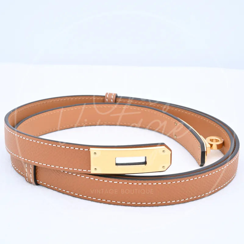 Hermès Kelly Belt in gold epsom leather with gold-tone hardware, featuring rectangular metal buckle and coiled leather strap, front three-quarter view