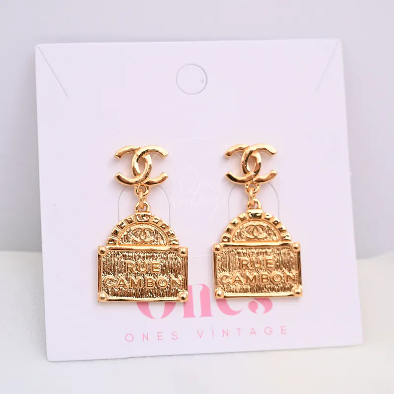 Chanel CC Rue Cambon Drop Earrings in gold-plated, featuring interlocking CC motifs and dangling rectangular plaques, front view
