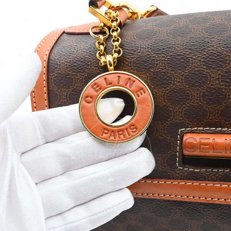 Close-up of vintage Céline Paris engraved leather and gold-tone metal ring charm
