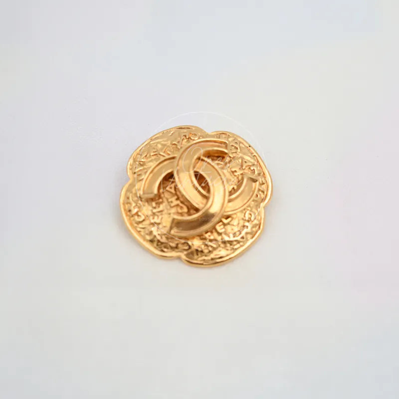 Chanel GP Coco Mark 24K Brooch in 24K gold, featuring interlocking CC emblem and scalloped ornamental border, front view