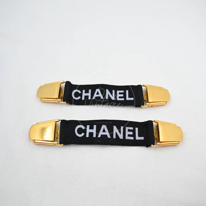 Chanel Logo-jacquard Armbands in black and gold, featuring gold-tone end buckles and black jacquard bands, front view