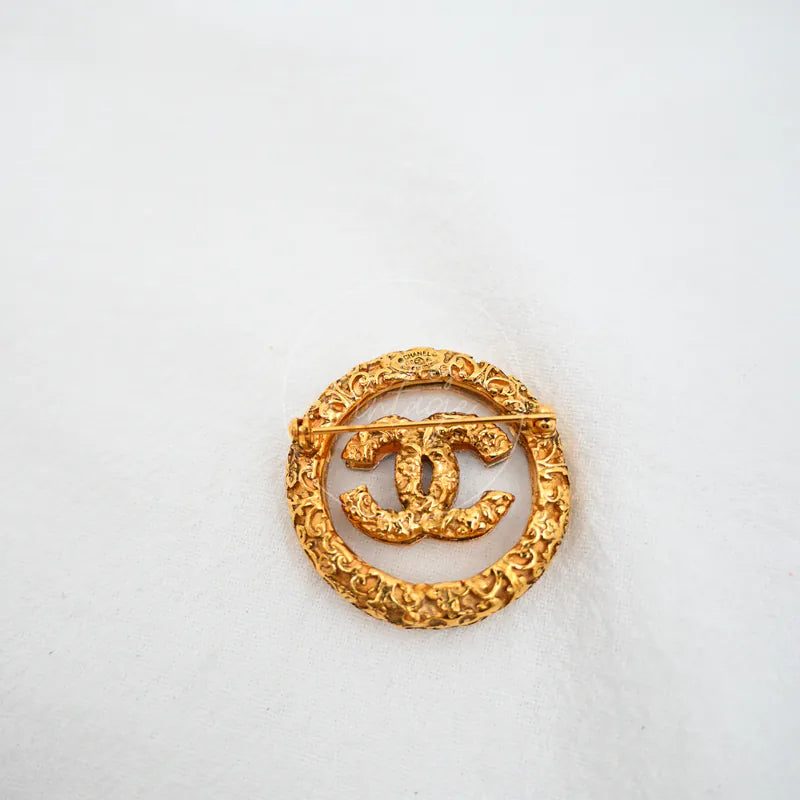 Chanel Broche Met Textuur Dames in gold-plated, featuring interlocking CC motif and ornate circular textured frame, front view