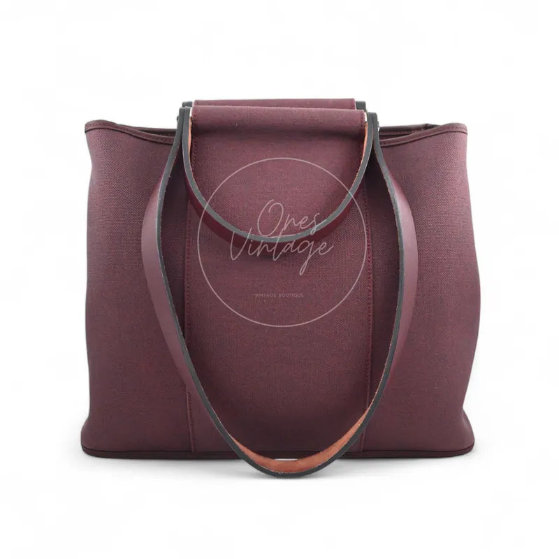 Hermès Cabag 32 tote in burgundy canvas with brown leather handles, T stamp, front view with long handles