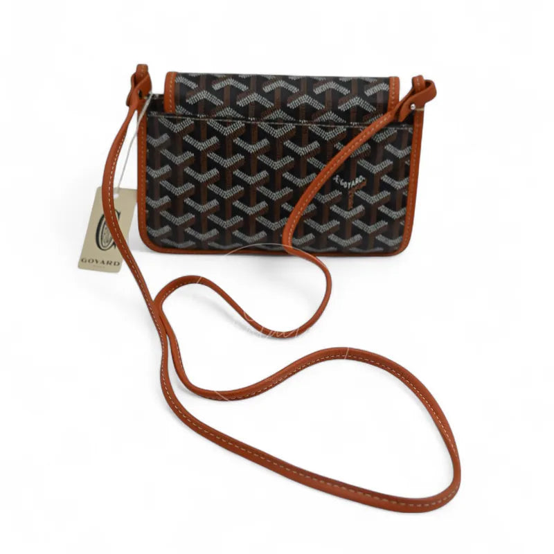 Goyard Plumet Pocket Wallet With Strap in black and tan, featuring geometric repeating canvas pattern with long shoulder strap, front view