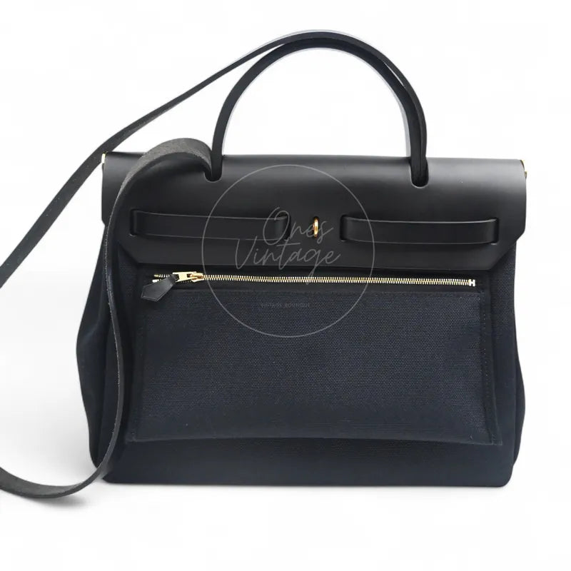 Hermès Herbag Zip 31 Canvas in black toile canvas and swift with gold-tone hardware, featuring top handles with long shoulder strap, front view