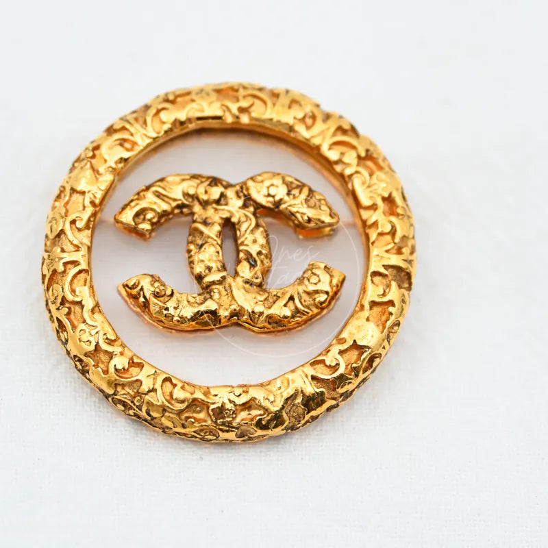 Chanel Broche Met Textuur Dames in gold-plated, featuring interlocking double-C motif and circular textured frame, front view