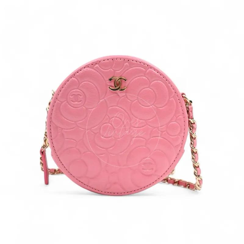 Chanel round clutch bag in pink camellia-embossed caviar leather with gold hardware, Series 29, front view with CC logo