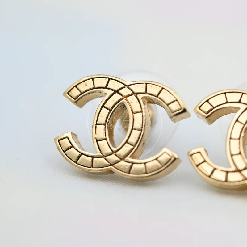 Chanel Film Pattern CC Mark Stud Earrings in gold-plated, featuring interlocking CC motif and segmented film-pattern detailing, front view