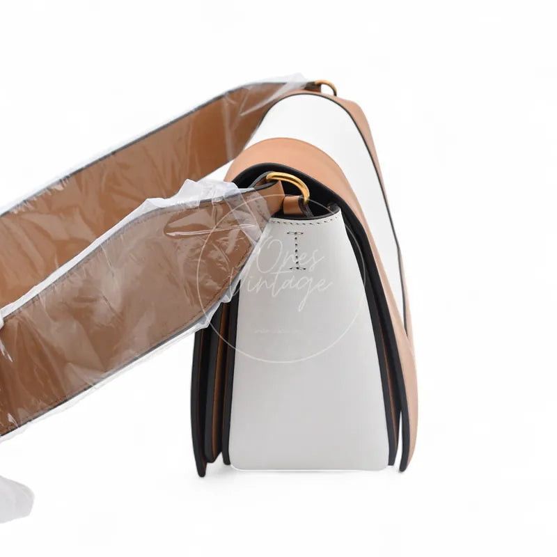 Celine Medium Frame Bag in tan and optic white calfskin, featuring structured tapered silhouette with long shoulder strap, front three-quarter view