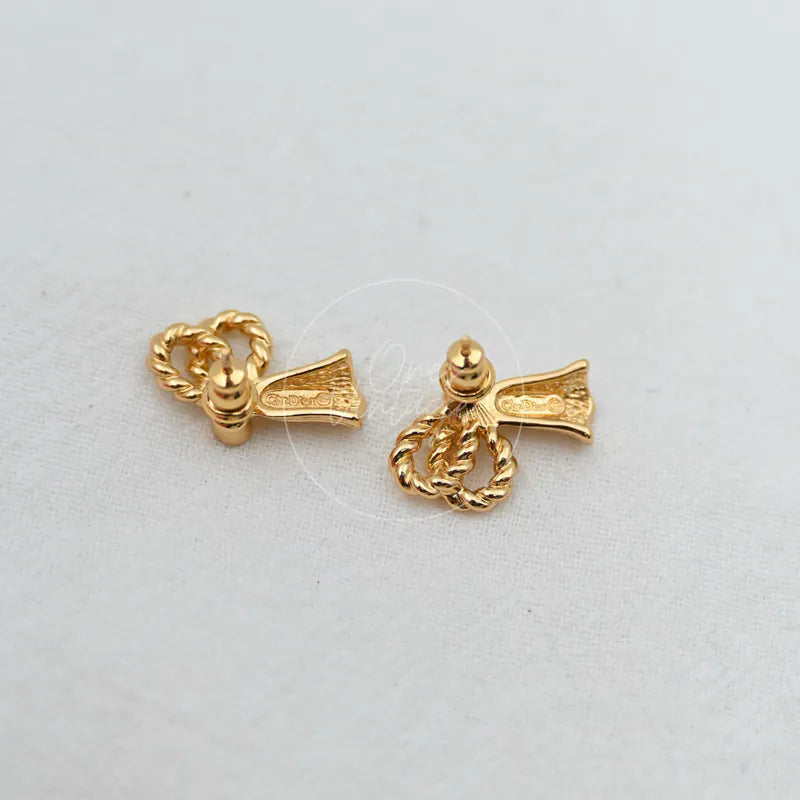 Dior Pierced Earrings in gold plate, featuring rope-textured loop motifs and textured bow-shaped fronts, front view