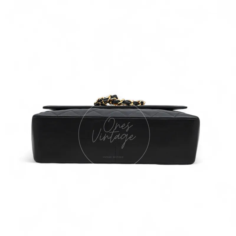 Chanel Vintage Maxi CC Straight Flap Bag in black lambskin, featuring flat rectangular base and smooth black leather surface, base view
