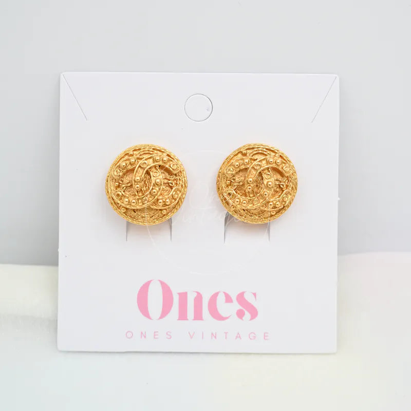 Chanel Vintage CC Filigree Round Clip-On Earrings in gold-plated, featuring round textured medallion faces and ornate raised swirl pattern, front view