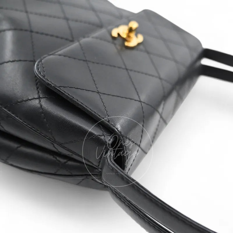 Chanel vintage turn-lock shoulder bag in black quilted lambskin with gold hardware, Series 5, front left corner and flap edge