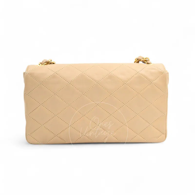 Chanel Vintage Single Flap bag with big CC in beige lambskin, featuring rounded rectangular silhouette and gold-tone chain visible at top, back view