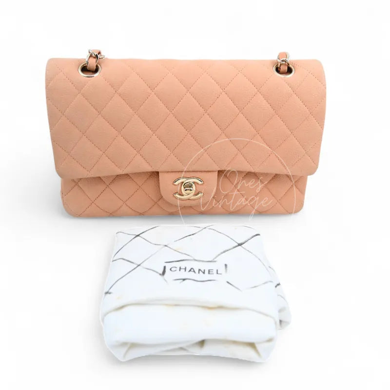 Chanel CF25 Medium Classic Flap Bag in peach caviar with gold-tone hardware, featuring CC turn-lock clasp with branded dust bag, front view