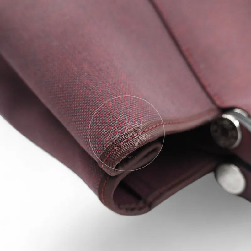 Hermès Cabag 32 tote in burgundy canvas with brown leather handles, T stamp, front left base corner