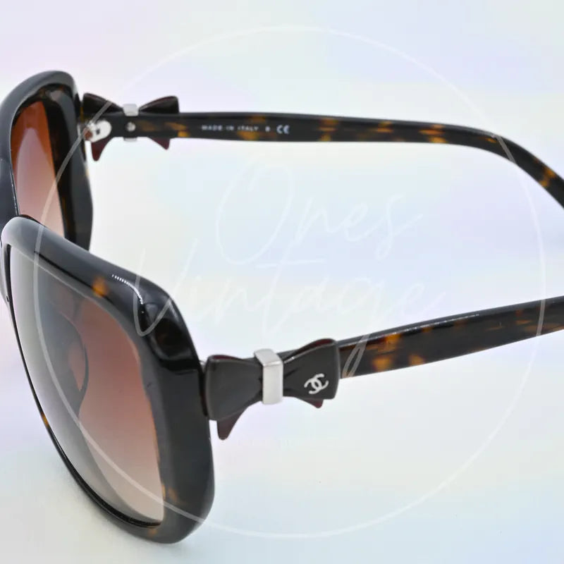 Chanel Sunglasses in black tortoiseshell, featuring interlocking CC logo and tortoiseshell temples, front three-quarter view