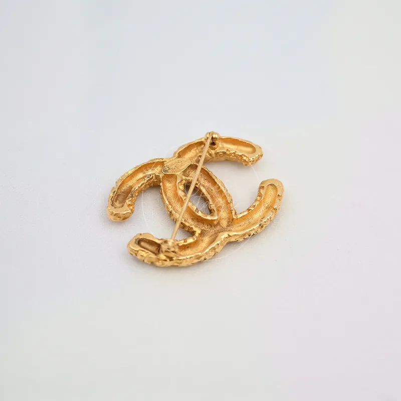 Chanel Vintage CC Mark Brooch in 24K gold-plated, featuring brooch pin fastening and textured metal reverse, back view