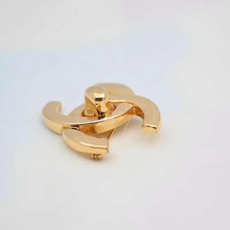 Chanel Vintage CC Logo 24K Plated Brooch in 24K gold-plated, featuring interlocking CC logo form and curved polished surfaces, front view