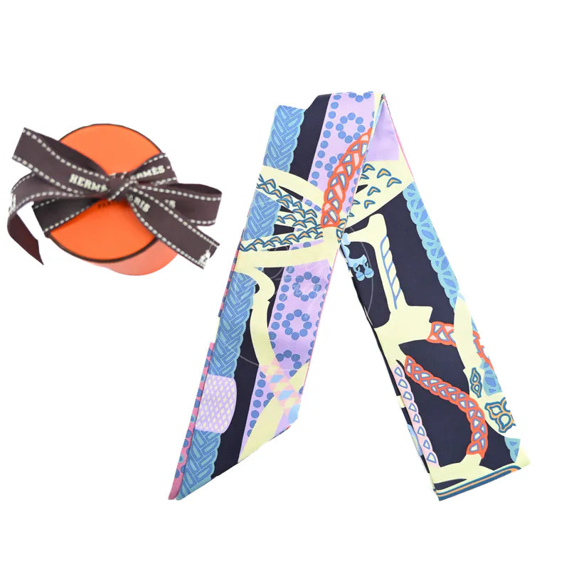 Hermès Fantaisie d'Etriers Twilly in marine, mauve and jaune soufre silk 100%, featuring Printed silk twilly scarf, front view