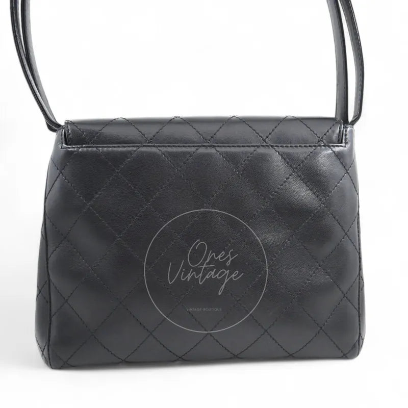 Chanel vintage turn-lock shoulder bag in black quilted lambskin with gold hardware, Series 5, rear view with diamond quilting