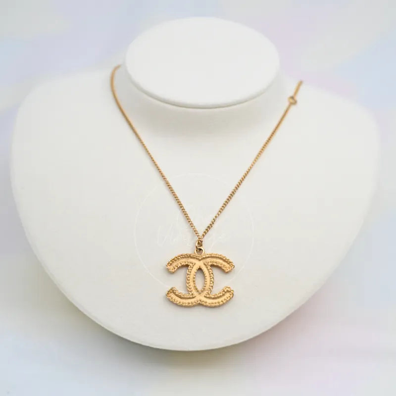 Chanel CC Mark Textured Logo Necklace in gold-plated, featuring textured interlocking CC pendant and lobster clasp, front view