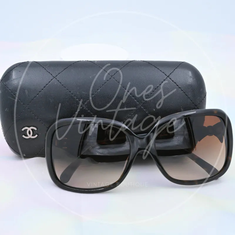 Chanel Sunglasses in black tortoiseshell, featuring interlocking CC emblem and tinted lenses, front view