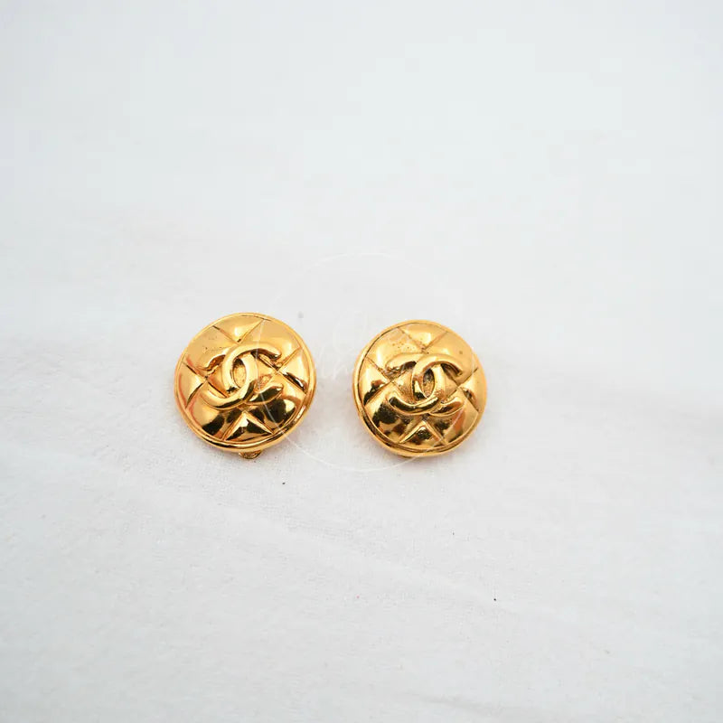 Chanel Clip on Earrings in gold plated, featuring interlocking CC motifs and round domed faces, front view