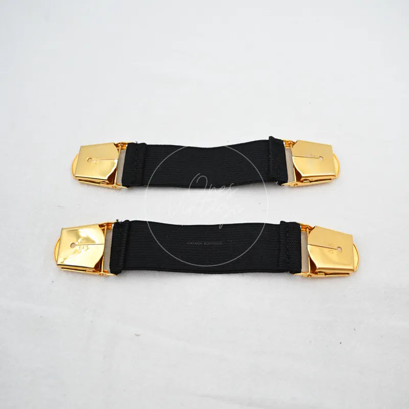 Chanel Logo-jacquard Armbands in black and gold, featuring rectangular clasp panels and paired black fabric armbands, front view