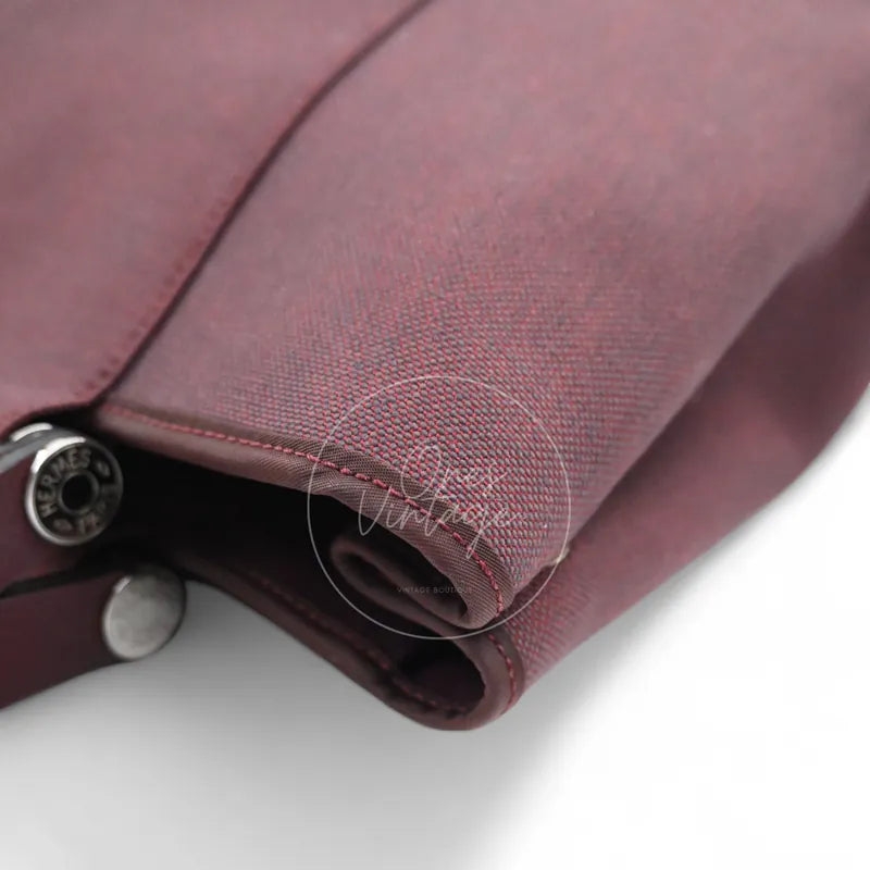 Hermès Cabag 32 tote in burgundy canvas with brown leather handles, T stamp, front right base corner