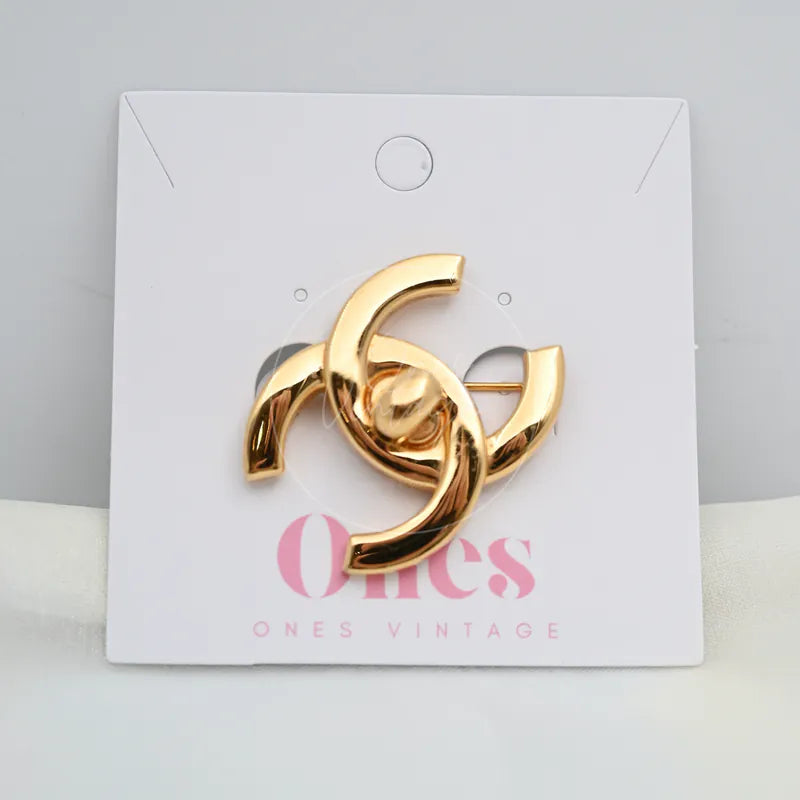 Chanel Vintage CC Logo 24K Plated Brooch in 24K gold-plated, featuring interlocking CC logo and curved polished metal forms, front view