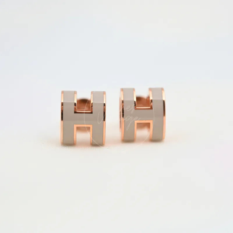 Hermès Mini Pop H Earrings Grey With Pink Gold in gold-plated alloy metal, featuring paired H-shaped stud earrings and grey-toned faces, front view