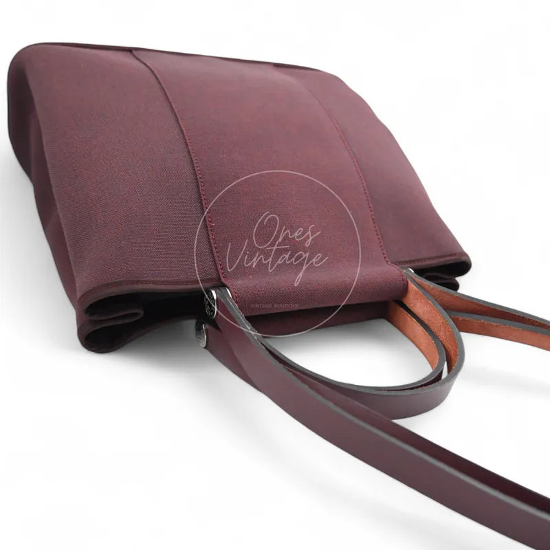 Hermès Cabag 32 tote in burgundy canvas with brown leather handles, T stamp, top view with handles folded
