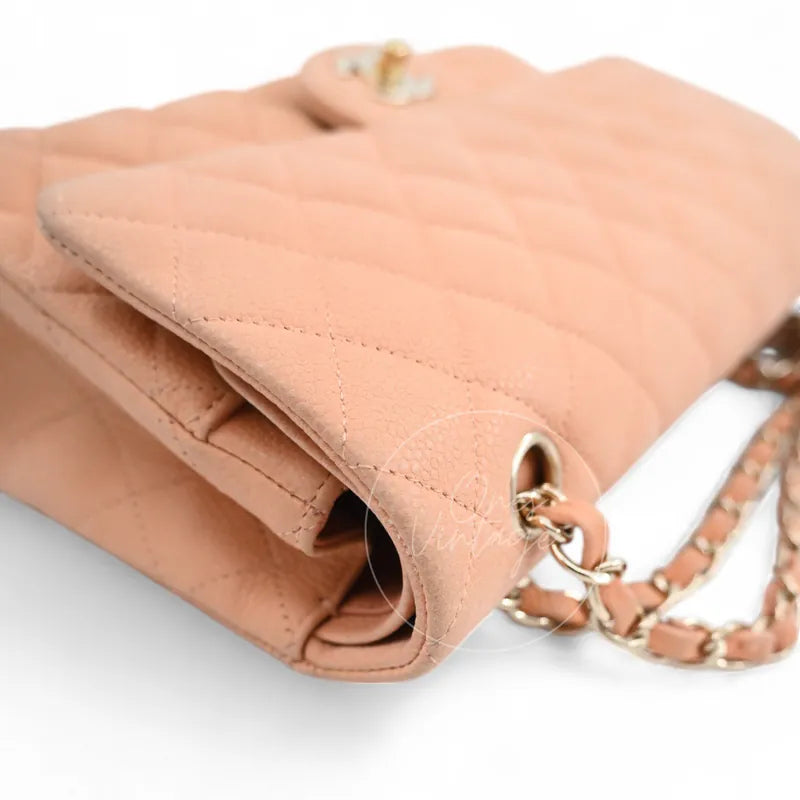 Chanel CF25 Medium Classic Flap Bag in peach caviar, featuring gold-tone strap attachment ring with chain-and-leather shoulder strap, right side view