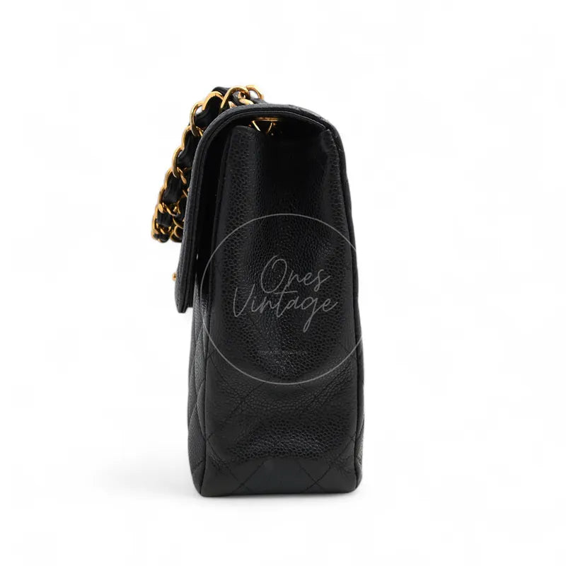 Chanel Jumbo Classic Flap Bag in black caviar with gold-tone hardware, featuring interwoven chain strap and structured flap silhouette, left side view