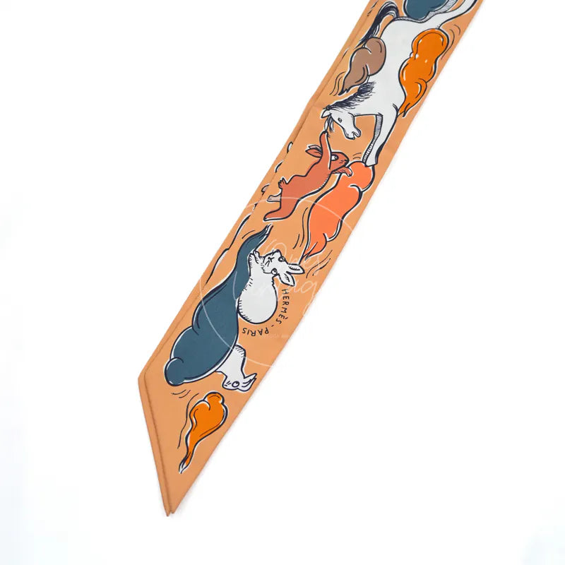 Hermès Mille et Un Lapins Twilly in orange silk 100%, featuring orange animal print and narrow scarf silhouette, front view