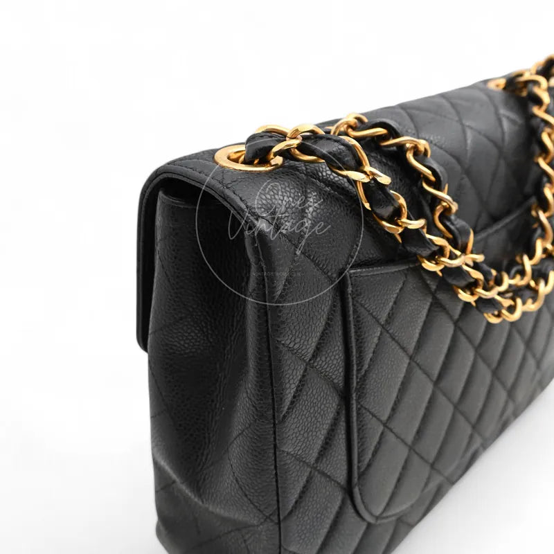 Chanel Jumbo Classic Flap Bag in black caviar with gold-tone hardware, featuring woven chain strap and side gusset, front three-quarter view