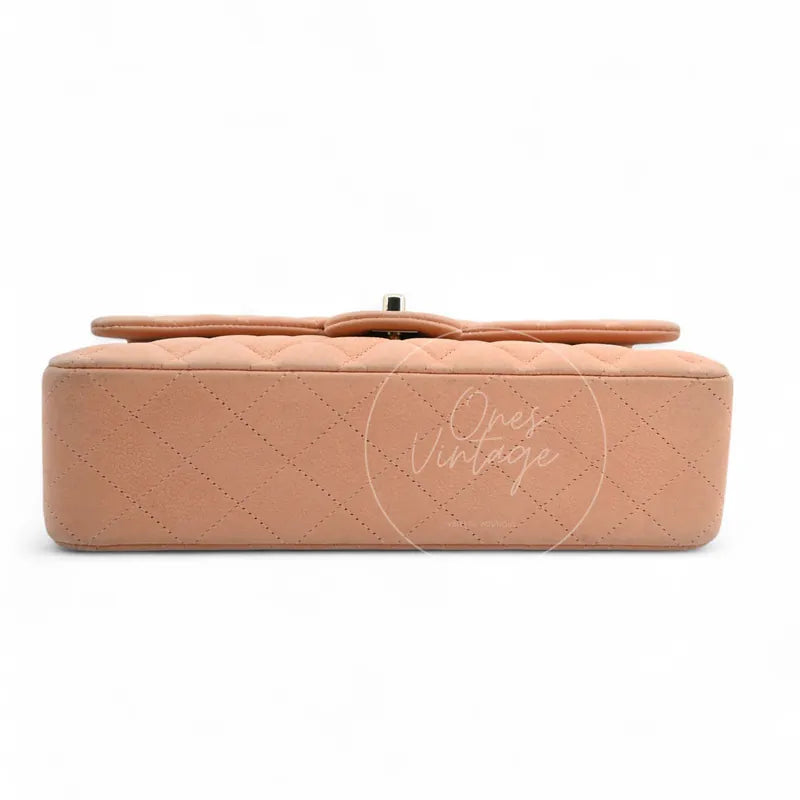 Chanel CF25 Medium Classic Flap Bag in peach caviar with gold-tone hardware, featuring rounded rectangular silhouette and top strap detail, back view
