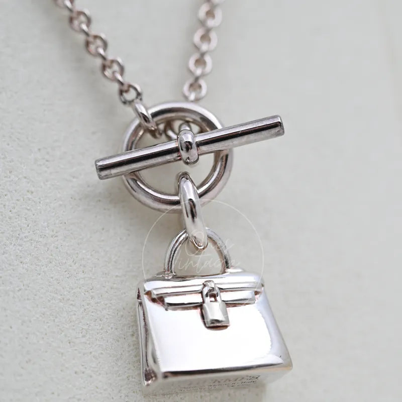 Hermès Amulettes Kelly Pendant Necklace, front flap and lock detail and miniature handbag-shaped pendant detail