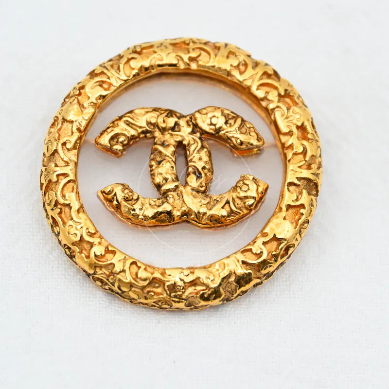 Chanel Broche Met Textuur Dames in gold-plated, featuring interlocking CC motif and ornate circular textured frame, front view