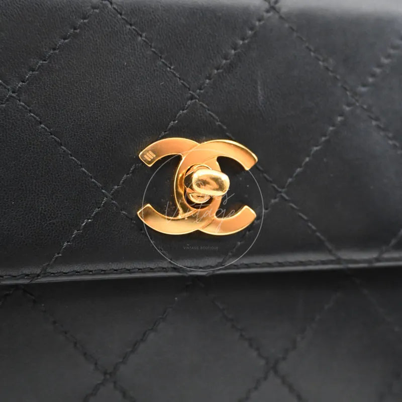 Chanel vintage turn-lock shoulder bag in black quilted lambskin with gold hardware, Series 5, gold CC turn-lock close-up